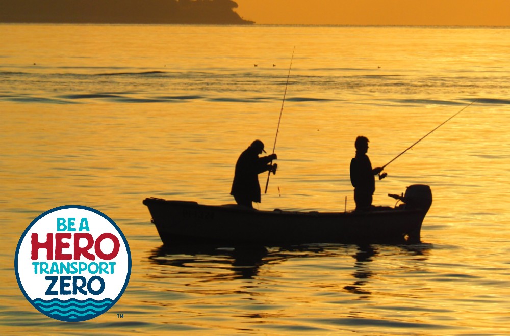 Two anglers in a boat are silhouetted on the water at sunset. Superimposed on the bottom left corner is a circular logo with the text 